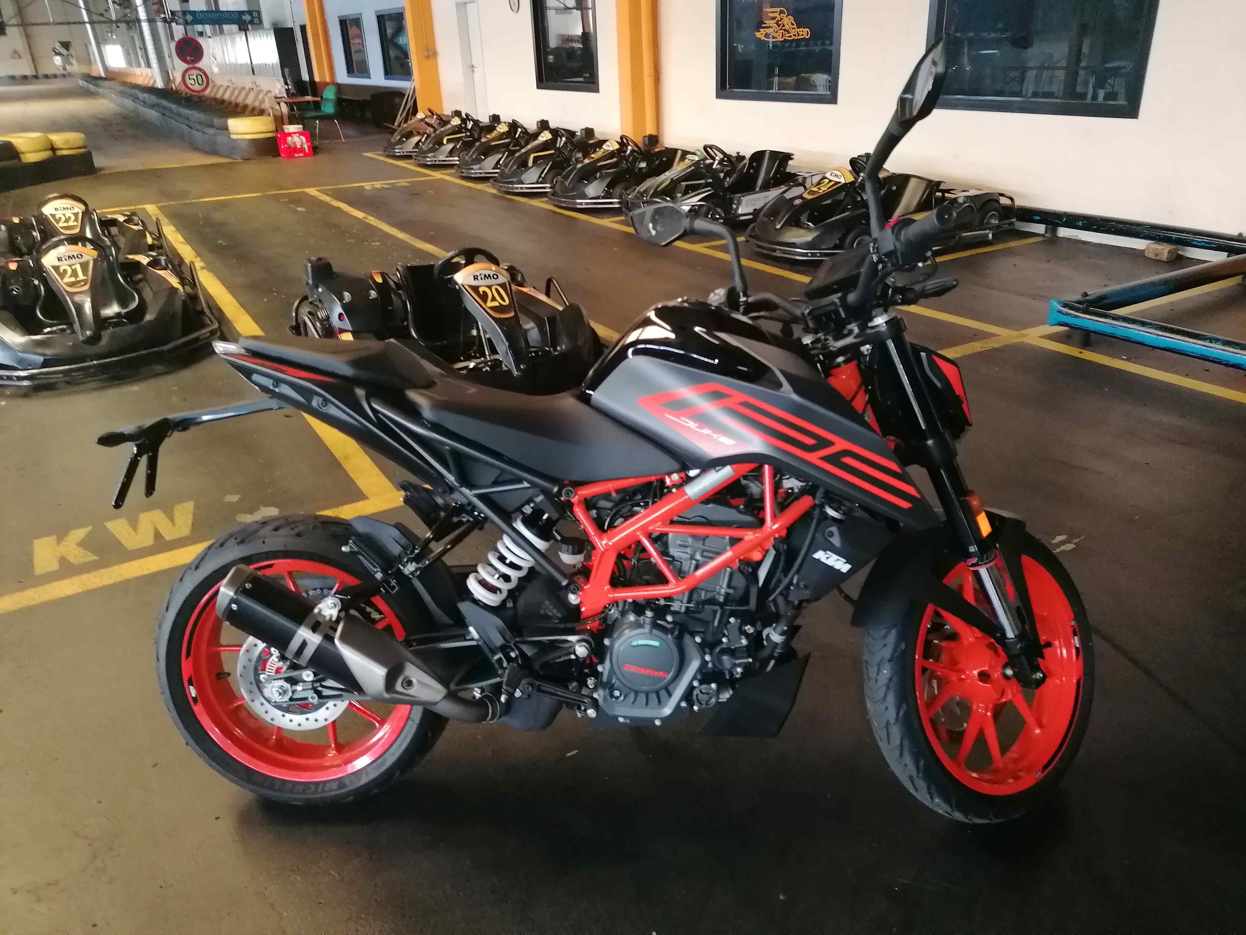 Black and red KTM Duke 125 motorcycle in the kart hall